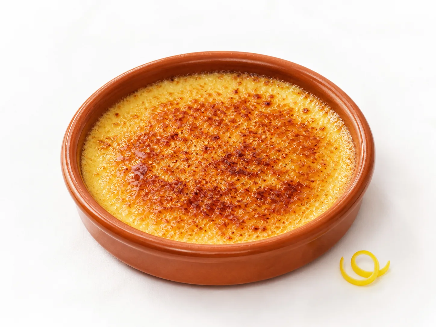 Crema catalana in een aardewerken schaaltje op een witte achtergrond